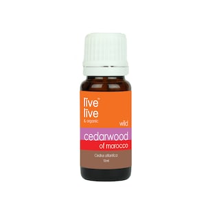 May include: A small amber glass bottle with a white cap, containing cedarwood essential oil. The label is orange and pink and reads "live live & organic wild cedarwood of morocco Cedrus atlantica 10ml".
