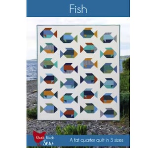 Peut inclure: Une courtepointe blanche avec un motif répété de poissons colorés dans les tons de bleu, vert, orange et marron. Le mot "Fish" est affiché dans une bannière bleue en haut. La courtepointe est un quilt de fat quarter en 3 tailles.