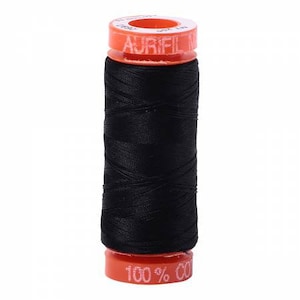 Pode incluir: Uma bobina de fio preto com um rótulo laranja que diz "Aurifil 100% Algodão".