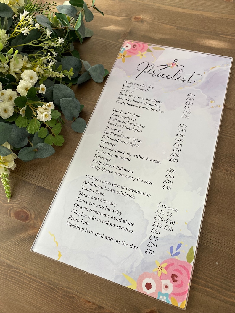 May include: A price list for hair salon services. The list includes prices for wash and blow dry, root touch up, highlights, weaves, balayage, color correction, toners, olaplex treatments, prom hair, and wedding hair.