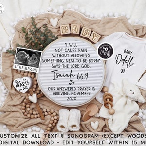 May include: A white wooden round sign with the text "I will not cause pain without allowing something new to be born' says the Lord God. Isaiah 66:9 Our answered prayer is arriving November 202X" with a black and white ultrasound image, a white onesie with the text "Baby Odell" and a white stuffed animal on a tan blanket with wooden beads and a wooden cross.
