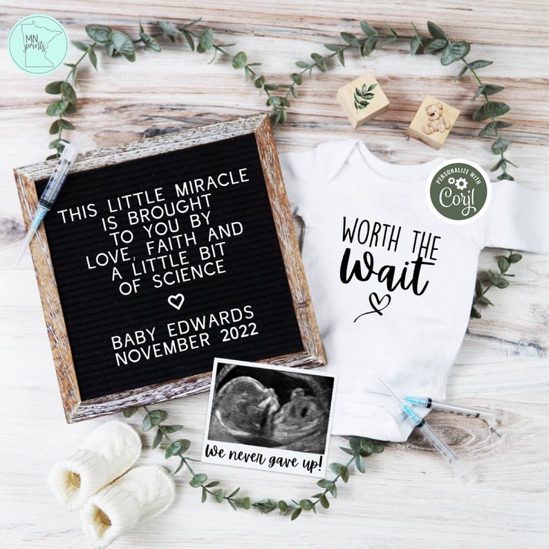 May include: A white onesie with the text "Worth the Wait" and a heart. A black letter board with the text "This little miracle is brought to you by love, faith and a little bit of science. Baby Edwards November 2022". A black and white ultrasound image with the text "We never gave up!"