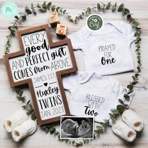 May include: A wooden cross with the text "Every good and perfect gift comes from above" and "James 1:17". Below the text is "Huxley Twins" and "Jan. 2023". Two white onesies with the text "Prayed for One" and "Blessed with Two" are displayed with a black and white ultrasound image.