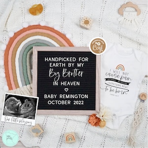 May include: A black letter board with the text "Handpicked for Earth by my Big Brother in Heaven" and "Baby Remington October 2022". A white onesie with the text "I will not cause pain without allowing something new to be born" and a rainbow graphic. A black and white ultrasound image is in the lower left corner.