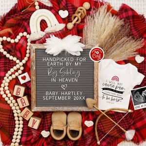 May include: A letter board with the text "HANDPICKED FOR EARTH BY MY BIG SIBLING IN HEAVEN" and "BABY HARTLEY SEPTEMBER 20XX". A white onesie with a rainbow and the text "I WILL NOT CAUSE PAIN WITHOUT ALLOWING SOMETHING NEW TO BE BORN" is next to the letter board. A small ultrasound image is next to the onesie with the text "LOVE AT FIRST SIGHT".