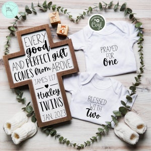 May include: A wooden cross with the text "Every good and perfect gift comes from above" and "James 1:17". Below the text is "Huxley Twins" and "Jan. 2023". Two white onesies with the text "Prayed for one" and "Blessed with two".