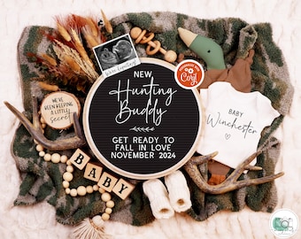 May include: A black letter board with the text "New Hunting Buddy Get Ready to Fall in Love November 2024". A white onesie with the text "Baby Winchester" and a heart. A wooden block with the word "Baby" on it. A brown antler, a green duck, and a small wooden toy.