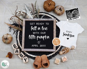 May include: A fall-themed baby announcement with a black letter board that reads "GET READY TO fall in love WITH OUR little pumpkin APRIL 20XX". There are pumpkins, a baby onesie that says "BABY Sanderson", a wooden block that says "BABY", and a pair of brown baby moccasins.