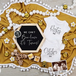 Può includere: Una coperta gialla con pompon bianchi attorno al bordo. Due body bianchi con testo nero, uno dice "Nectar Twins" e l'altro dice "Ottobre 2023". Un pannello di lettere nero con il testo "We can't Bee-lieve it's Twins!" e una piccola immagine di ecografia con il testo "Sweet as can bee".