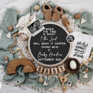 May include: A baby announcement with a white onesie, a letter board with text, and wooden blocks spelling "BABY." The announcement includes a sonogram, baby shoes, and decorative elements.