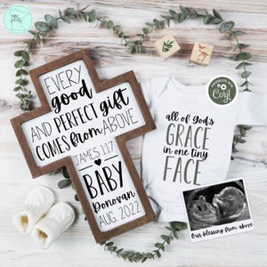 May include: A wooden cross with the text "Every good and perfect gift comes from above" and "James 1:17". Below the text is "Baby Donovan Aug. 2022". A white onesie with the text "All of God's Grace in one tiny face" and a black and white ultrasound image.