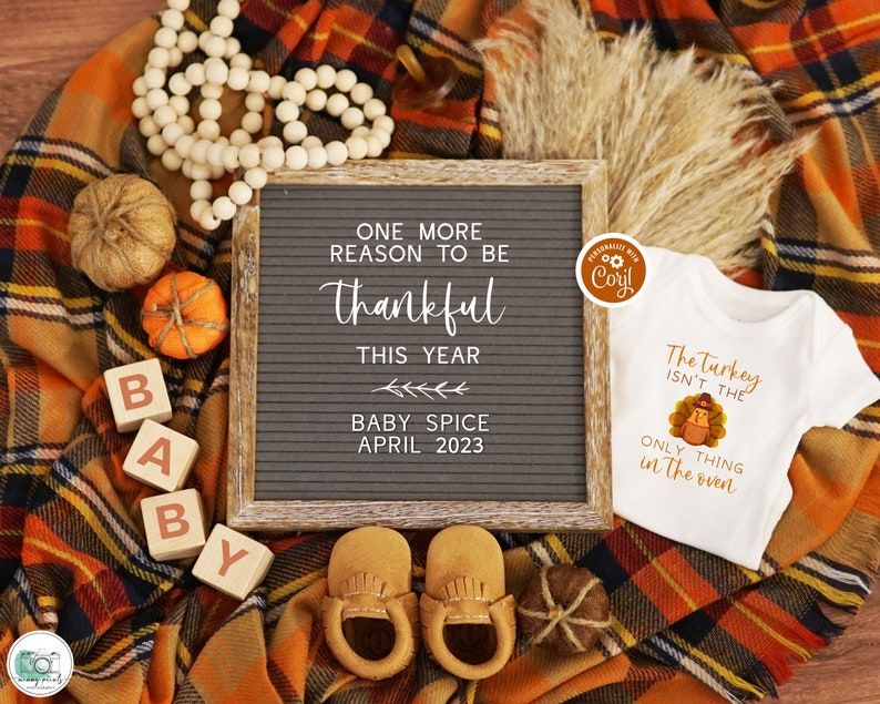 K&ouml;nnte beinhalten: Eine Baby-Ank&uuml;ndigung zum Thema Thanksgiving mit einem Buchstabenbrett, auf dem "One more reason to be thankful this year Baby Spice April 2023" steht. Au&szlig;erdem sind Holzbl&ouml;cke zu sehen, die "BABY" buchstabieren, ein Strampler mit einem Truthahn-Motiv und dem Text "The Turkey isn't the only thing in the oven" sowie kleine dekorative K&uuml;rbisse.