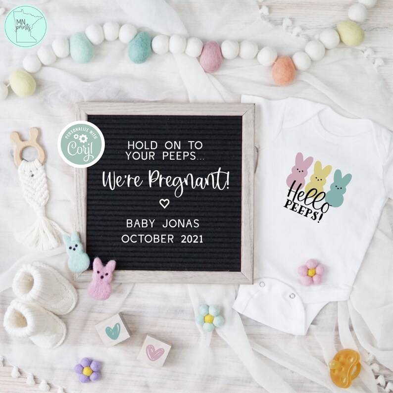 May include: A pregnancy announcement with a black letter board that reads "Hold on to your peeps... We're Pregnant! Baby Jonas October 2021". A white onesie with three pastel-colored Peeps and the text "Hello Peeps!" is next to the letter board. The onesie is surrounded by pastel-colored felt balls and flowers.