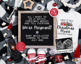 May include: A black and white letter board with the text "All I want to do is watch Christmas movies and tell everyone We're Pregnant! Baby McCallister coming to town July 2022". A white onesie with the text "This is my Christmas Movie Watching Onesie" and a black and white ultrasound image are also in the photo.