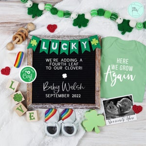 Puede incluir: Un tablero de letras negro con el texto "LUCKY" en letras de fieltro verde, un trébol verde y el texto "WE'RE ADDING A FOURTH LEAF TO OUR CLOVER! Baby Walsh SEPTEMBER 2022". Un body verde con el texto "HERE WE GROW Again" en blanco. Un par de zapatos de bebé arcoíris. Un trébol verde. Una imagen de ultrasonido enmarcada con el texto "One more to Abre".
