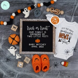 May include: A Halloween-themed baby announcement with a black chalkboard sign that reads "trick or treat our family is growing by two little feet! Baby Witchey April 2022". A white onesie with the text "It's the most spooktacular news of the year" and a pumpkin and witch hat graphic. A pair of orange baby booties with a pumpkin face design.
