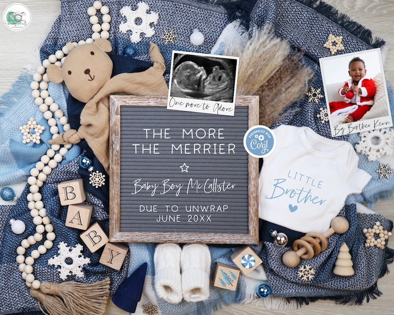 May include: A baby announcement with a letter board that reads "One more to More THE MORE THE MERRIER Baby Boy McCallster DUE TO UNWRAP JUNE 20XX". The board is surrounded by a blue blanket, a white onesie with the text "LITTLE BROTHER", a wooden toy, a wooden bead garland, a wooden block spelling "BABY", a small white ornament, a snowflake, and a framed ultrasound image.