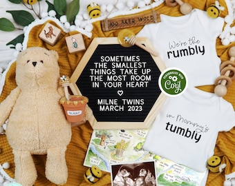 May include: A Winnie the Pooh themed baby announcement with a black letter board that reads "Sometimes the smallest things take up the most room in your heart."  The letter board also says "Milne Twins March 2023".  There are two white onesies with the text "We're the rumbly" and "in Mommy's tumbly".  There is a Winnie the Pooh stuffed animal, a map of the Hundred Acre Wood, and an ultrasound image.