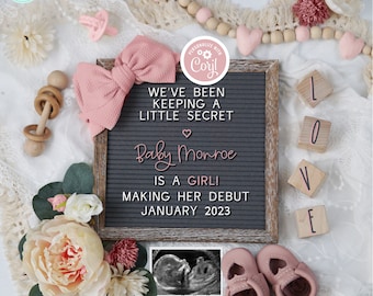 May include: A pink and gray letter board with the text "We've been keeping a little secret. Baby Monroe is a girl! Making her debut January 2023". The board is surrounded by pink and white flowers, a pink bow, wooden beads, and a wooden rattle. There is also a black and white ultrasound image and a pair of pink baby shoes.