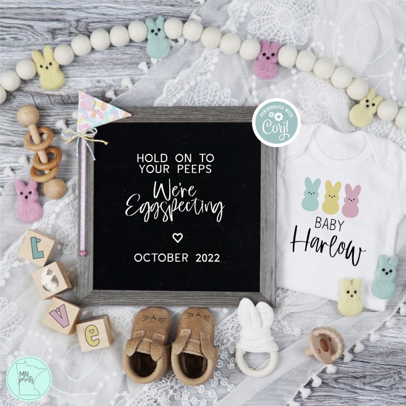 Peut inclure: Un panneau d'annonce en ardoise avec le texte "Hold on to your peeps We're Eggspecting October 2022" et un body blanc avec trois poussins jaunes pastel et le texte "Baby Harlow".