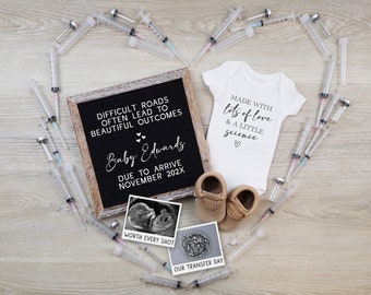 May include: A black letter board with the text "Difficult roads often lead to beautiful outcomes" and "Baby Edwards Due to arrive November 202X". A white onesie with the text "Made with lots of love & a little science" is next to the letter board. There are two brown baby moccasins and a black and white ultrasound image.