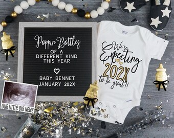 Puede incluir: Un tablero de letras negro con el texto "Poppin Bottles of a Different Kind This Year" y "Baby Bennet January 202X". Un body blanco con el texto "We're Expecting 202X to be great!!" y una imagen de ultrasonido en blanco y negro.