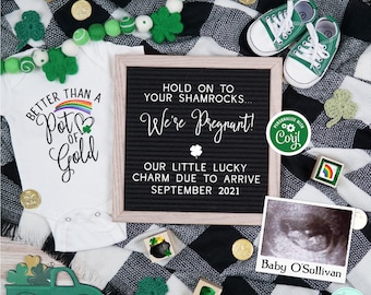 May include: A black and white checkered blanket with a white onesie that says "Better than a Pot of Gold" and a black letter board that says "Hold on to your shamrocks... We're Pregnant! Our little lucky charm due to arrive September 2021". There is a green baby shoe, a green truck, and a sonogram image that says "Baby O'Sullivan".