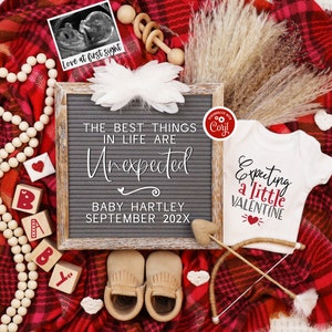K&ouml;nnte beinhalten: Eine rot-schwarze karierte Decke mit einem wei&szlig;en Strampler, auf dem "Expecting a little Valentine" mit einem roten Herzen steht. Es gibt eine Buchstabentafel, auf der "The best things in life are unexpected" mit dem Namen "Baby Hartley" und dem Datum "September 202X" steht.