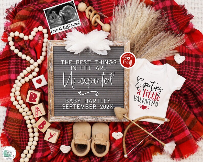 K&ouml;nnte beinhalten: Eine rot-schwarze karierte Decke mit einem wei&szlig;en Strampler, auf dem "Expecting a little Valentine" mit einem roten Herzen steht. Es gibt eine Buchstabentafel, auf der "The best things in life are unexpected" mit dem Namen "Baby Hartley" und dem Datum "September 202X" steht.