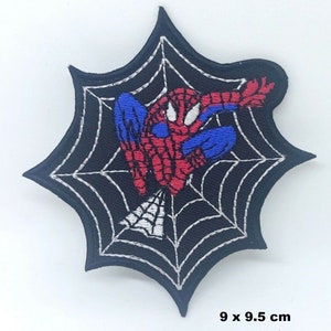 Könnte beinhalten: Gestickter Aufnäher mit Spider-Man in dynamischer Pose, vor einem schwarzen Spinnennetz-Design. Der Aufnäher ist ca. 9 x 9,5 cm groß. Der Superheld ist in seinem klassischen rot-blauen Anzug dargestellt.