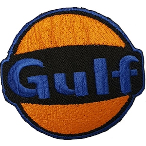 May include: A blue and orange embroidered patch with the word "Gulf" in blue lettering.