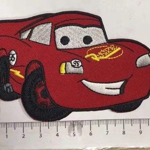 May include: Red embroidered iron-on patch of a cartoon car with a smiling face, black wheels, and the text "95" on the side.