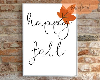 May include: A white printable sign with black calligraphy that reads "happy fall" with an orange leaf in the upper right corner.