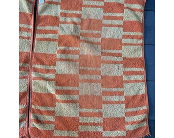 May include: Two vintage orange and cream-colored bath towels. The towels feature a checkered pattern with fringed edges. The towels are made of a soft, absorbent material, perfect for drying off after a shower or bath.