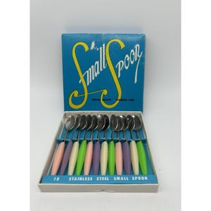 May include: A set of 12 small stainless steel spoons with pastel-coloured handles in a box. The box is blue with the words "Small Spoon". The handles are pink, purple, green, and white. The box reads "Stainless Steel".