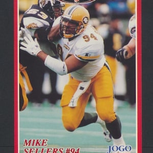 Peut inclure: Carte de collection de football avec Mike Sellers #94 en uniforme jaune et blanc. La carte a une bordure rouge et comprend le texte "Radically Canadian" et "Jogo Incorporated". L'image montre Sellers en action.