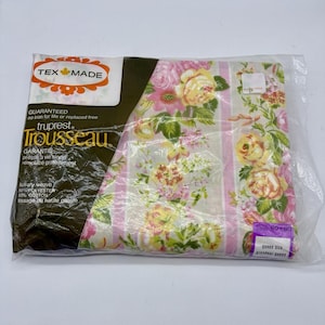 May include: A packaged Trousseau brand bed sheet featuring a floral pattern with yellow and pink roses on a cream background with pink stripes. The packaging includes the text Tex Made, Trousseau, luxury weave, 50% polyester, 50% cotton, and queen size.