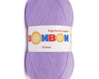 Può includere: Un gomitolo di filo di colore lilla chiaro con l'etichetta "Bonbon Kristal" e il testo "Örgü keyfini yaşayın".