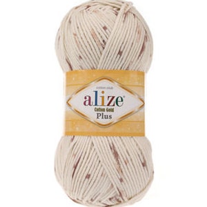 Puede incluir: Un ovillo de hilo de color crema con motas marrones. El hilo est&aacute; etiquetado como "Alize Cotton Gold Plus".