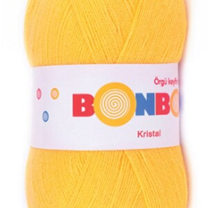 May include: A ball of bright yellow yarn with a white label that reads "Bonbon Orgu Keyfi Kristal".