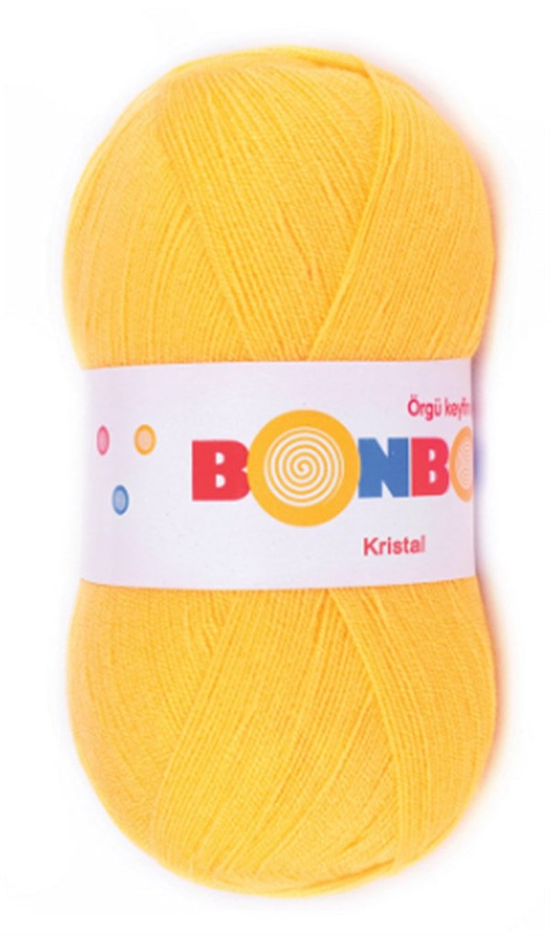 May include: A ball of bright yellow yarn with a white label that reads "Bonbon Orgu Keyfi Kristal".