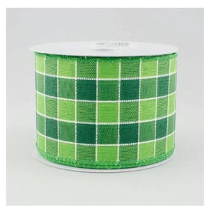 May include: A roll of green and white plaid ribbon. The ribbon features a repeating pattern of green squares in varying shades, separated by white lines. The ribbon is on a white spool.