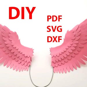Puede incluir: Proyecto de manualidades de alas de papel DIY. Alas de papel rosa con un diseño en capas. Formatos de archivo PDF, SVG y DXF disponibles.