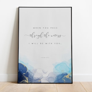 May include: A framed print with a white background and blue and gold watercolour design. The print features the text "When you pass through the waters I will be with you; Isaiah 43:2".