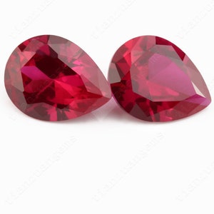 Peut inclure: Deux pierres précieuses rouges en forme de poire, chacune avec une taille brillante et un haut degré de clarté.