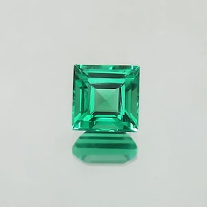 May include: A vibrant green emerald gemstone with a square cut and a polished finish.