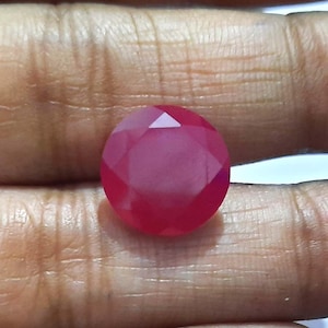 Op de afbeelding: Een gefacetteerde, ovale, roze edelsteen met een glad, gepolijst oppervlak.