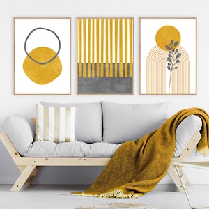 May include: Three abstract art prints in a minimalist style with a yellow and gray color scheme. The prints feature geometric shapes, lines, and a stylized plant.