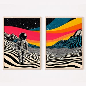 May include: Two framed illustrations of an astronaut walking on a striped desert landscape with a colorful sunset in the background. The astronaut is wearing a white spacesuit with a black helmet. The sunset is a gradient of red, orange, yellow, and blue.