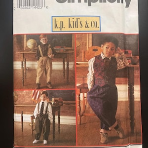 Puede incluir: Un sobre de patrón de costura Simplicity, número 8567, talla AA (3-6), con el texto k.p. kid's & co. La portada muestra tres fotografías de niños con diversos atuendos, incluyendo chalecos, pantalones con tirantes y camisas de botones.